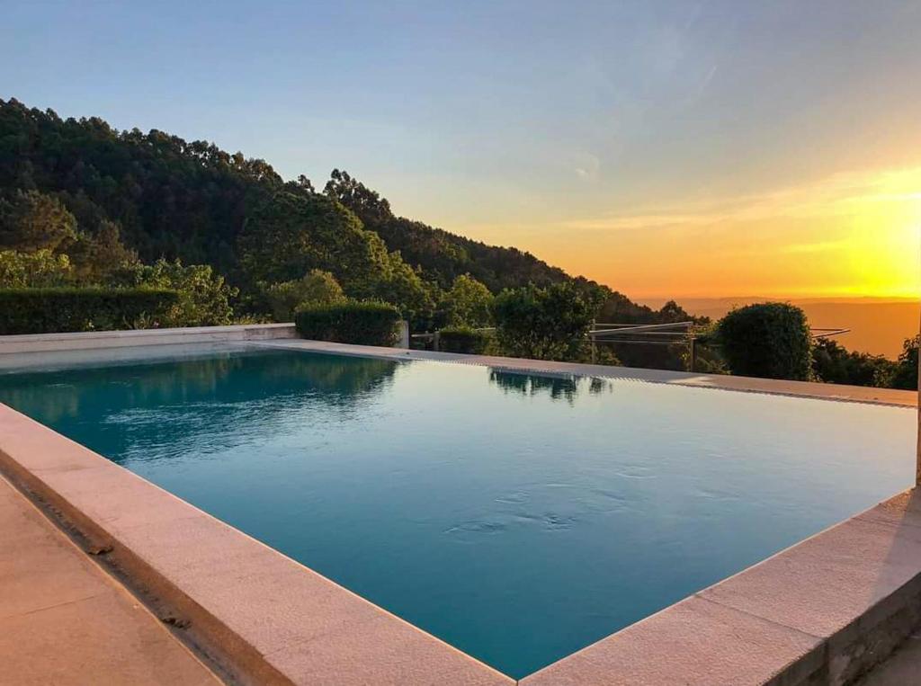 洛萨Pera da Serra - Turismo no Espaço Rural的一座享有日落美景的游泳池
