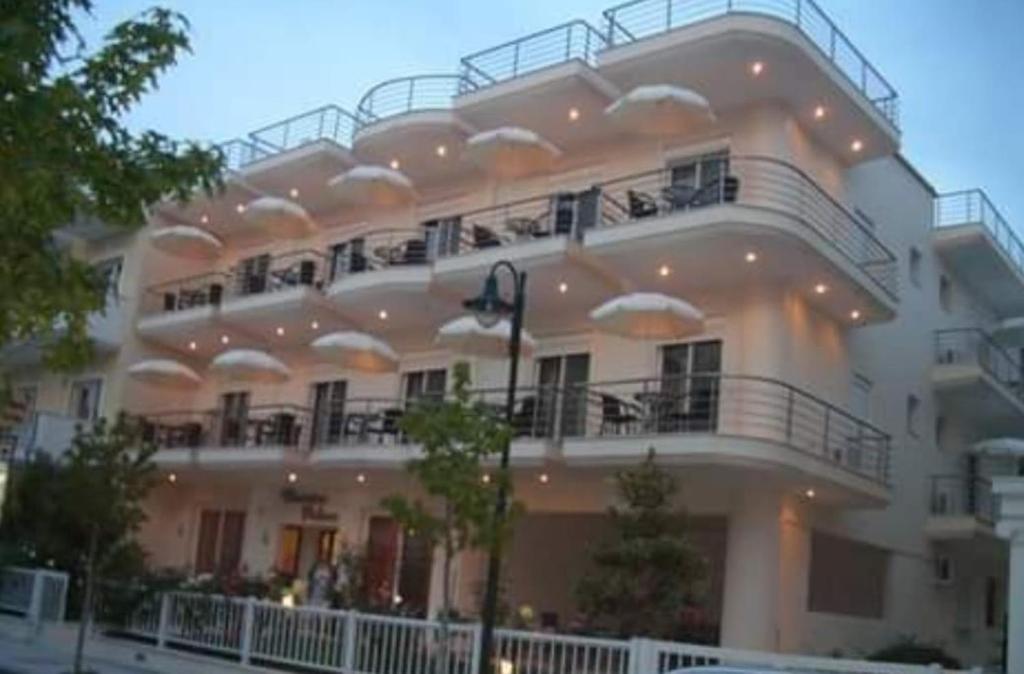 奥林匹亚基·阿克蒂Christina Hotel的大型白色建筑,设有大阳台