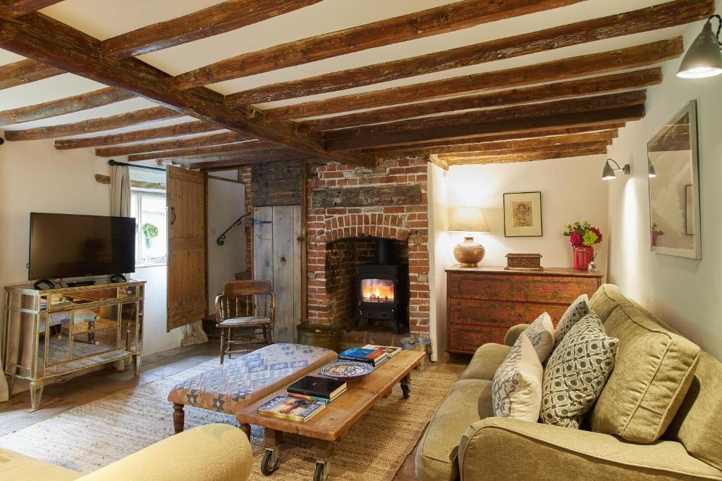 East RudhamRock Cottage的带沙发和壁炉的客厅