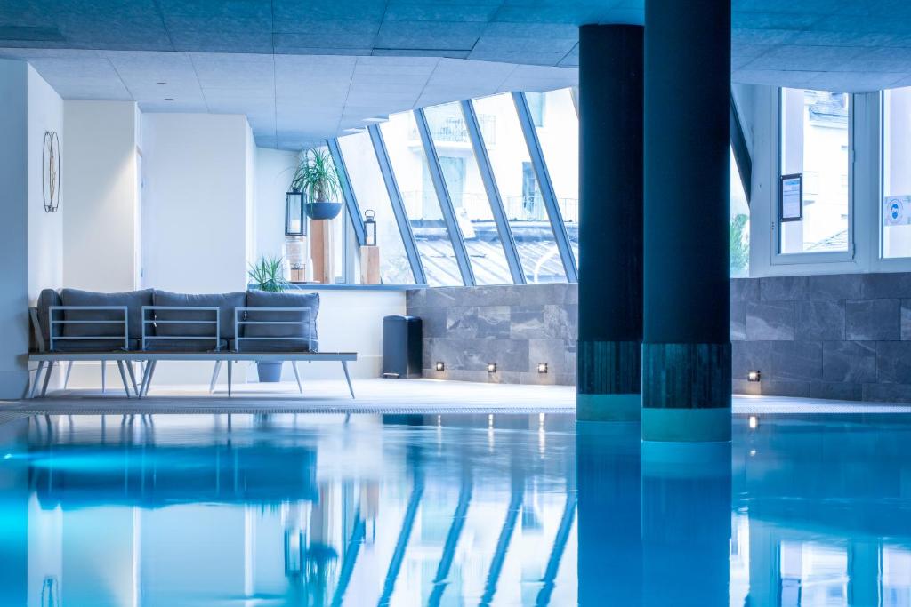 科特雷Garden & City Cauterets Balneo的一间带游泳池和沙发的客厅