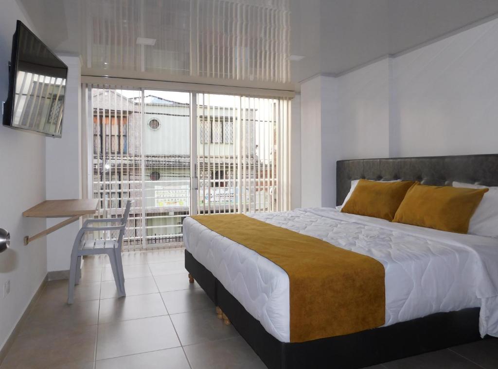 波帕扬Hotel Monarka-Edificio的一间卧室配有一张床、一张书桌和一个窗户。