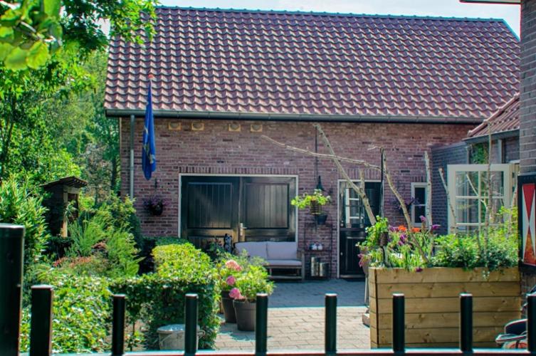 法尔肯斯瓦德Guesthouse Valkenswaard的前面有花园的砖房