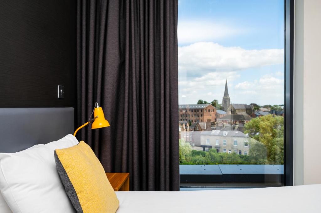 约克Staycity Aparthotels York的一间卧室设有一张床和一个大窗户
