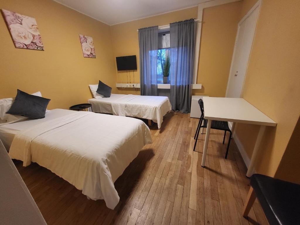 韦斯特罗斯IzKaMaGe Hotel 2的客房设有两张床、一张桌子和一扇窗户。