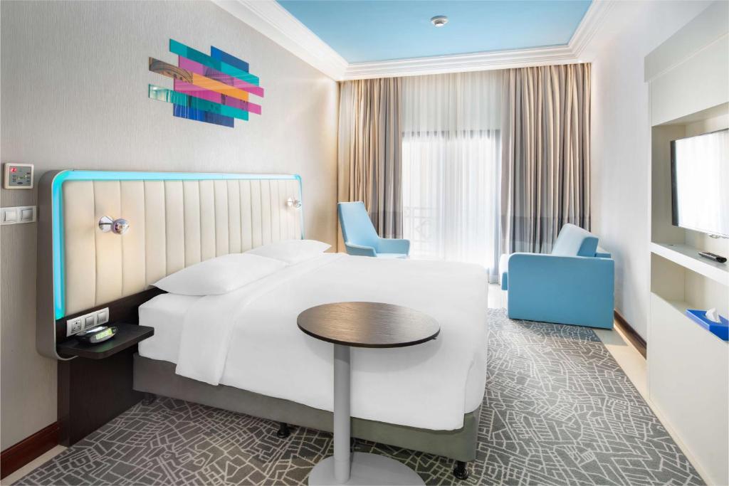 麦加麦加爱娜森瑞迪森帕克酒店的酒店客房带一张床、一张桌子和椅子