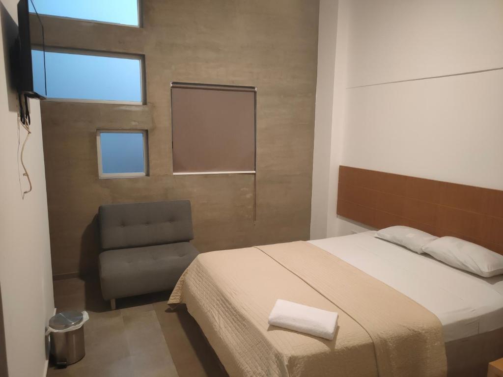 瓜亚基尔HOTEL BOUTIQUE PANAMÁ的一间卧室配有一张床和一把椅子