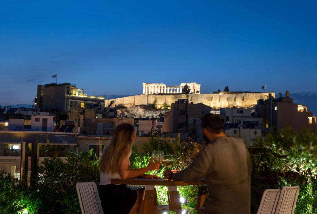 雅典雅典B4B签名酒店的坐在桌子上戴酒杯的男人和女人