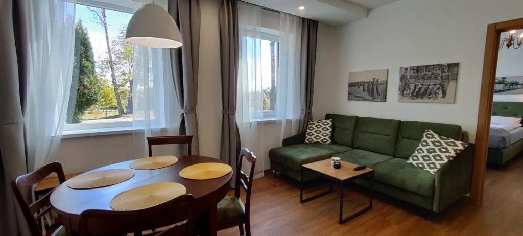 PagėgiaiExceptional Pogegen Apartment的客厅配有绿色沙发和桌子
