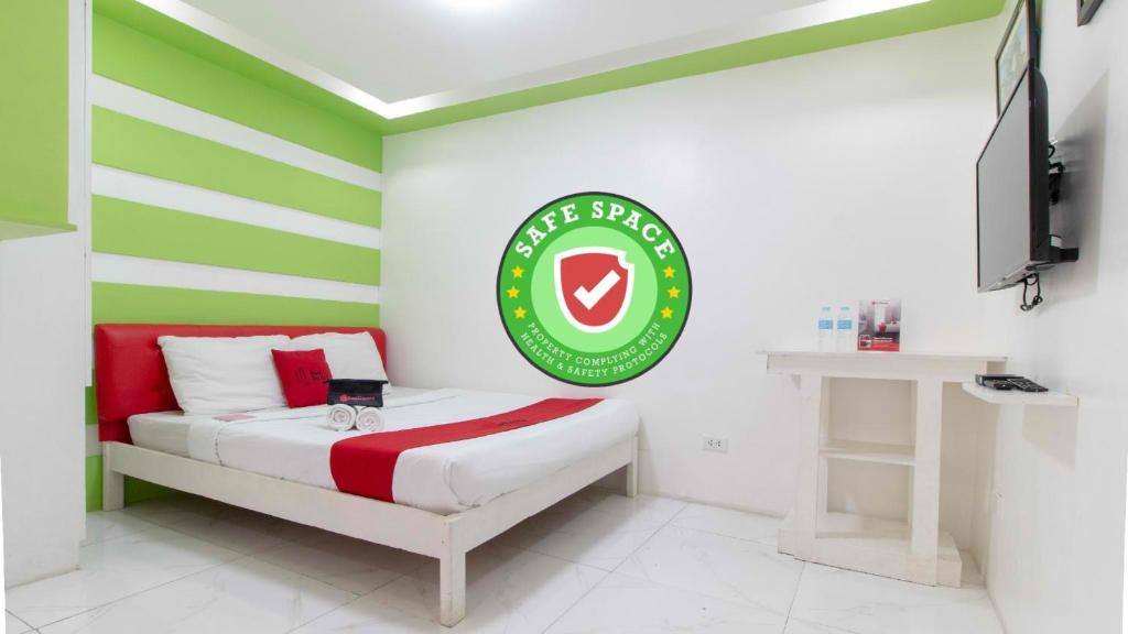 马尼拉RedDoorz at DBuilders Rooms Lower Bicutan的一间设有一张绿色和白色床条的房间