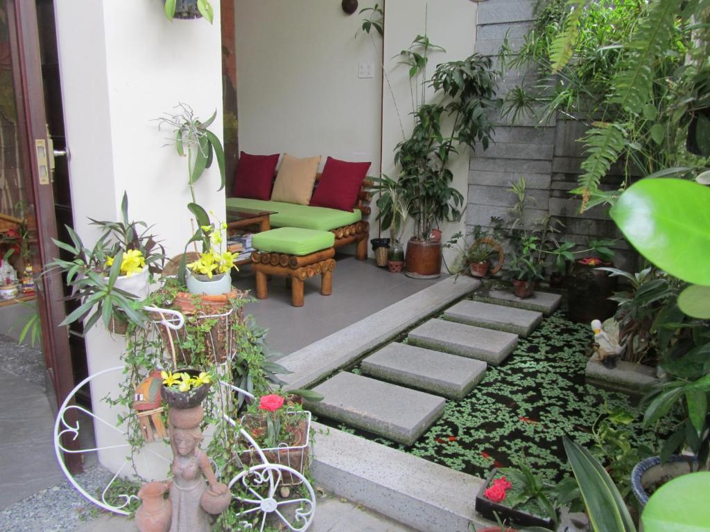 芽庄芽庄温馨小家公寓式酒店的带沙发和一些植物的庭院