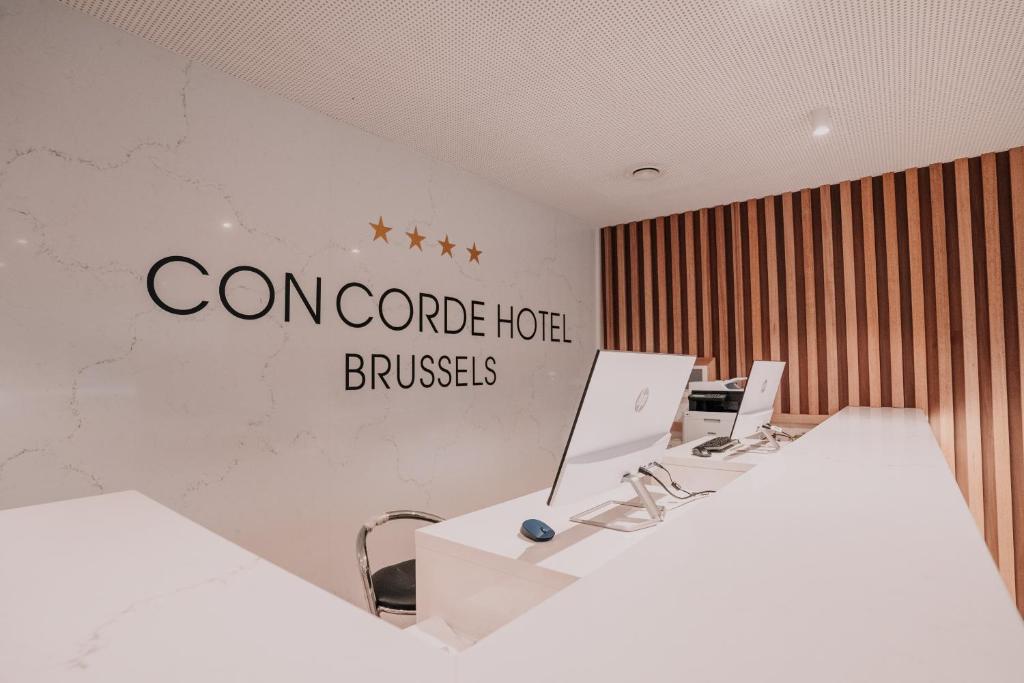 布鲁塞尔Hôtel Concorde的墙上有两张桌子和一个标志的办公室