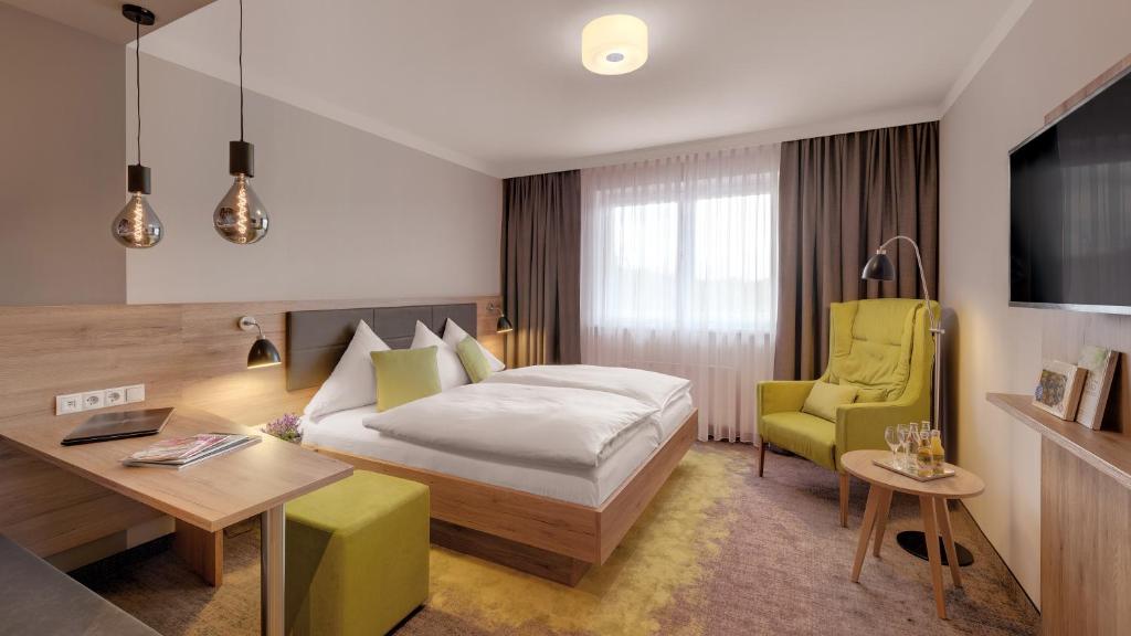 阿塞尔海姆阿塞汉姆普法索酒店的酒店客房,配有一张床、一张桌子和椅子