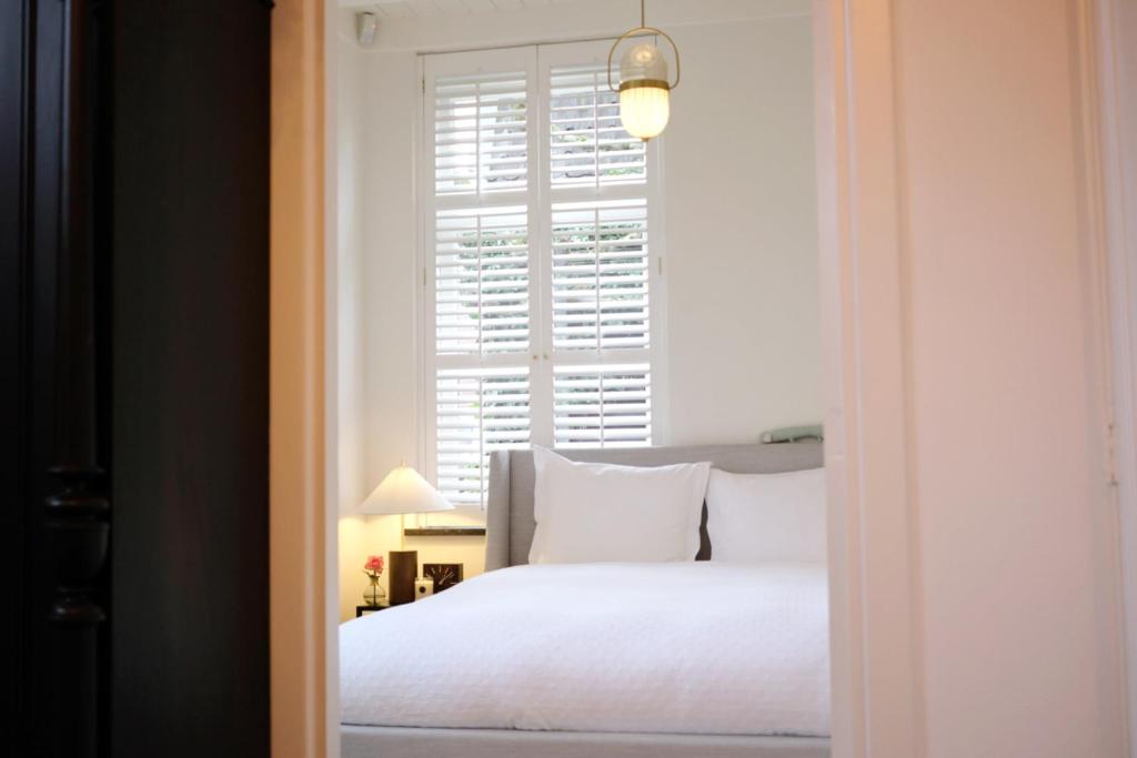 阿莫隆根La Vie en Roos Amerongen的卧室配有白色的床和窗户。