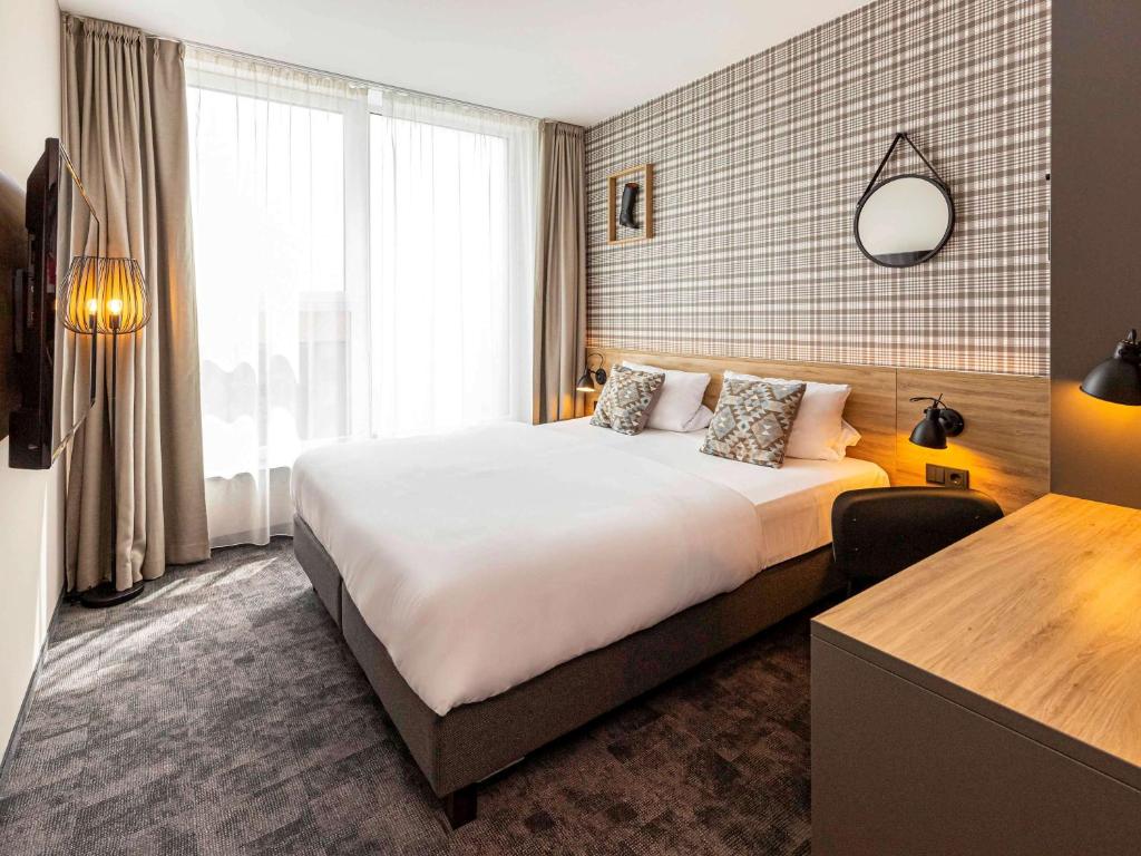 弗希塔ibis Styles Vechta的一间设有大床和窗户的酒店客房