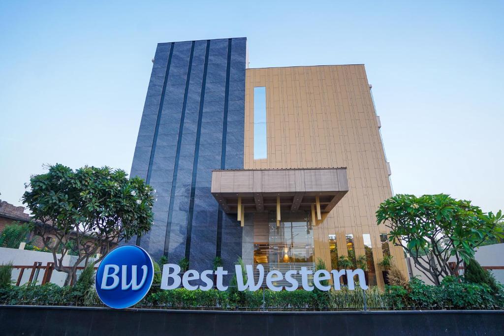 范兰德凡Best Western Vrindavan的前面有蓝色最好的西方标志的建筑