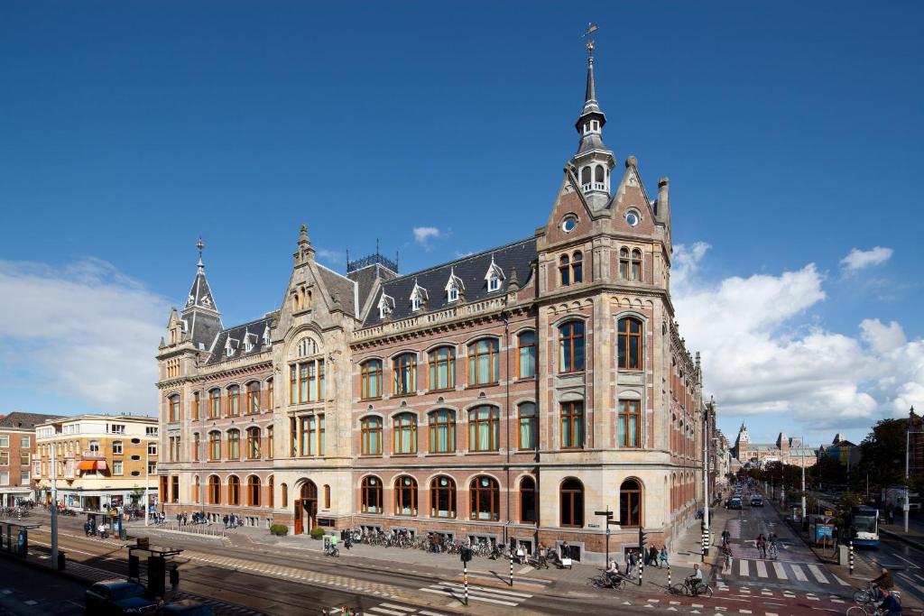 阿姆斯特丹Conservatorium Hotel的一座大型建筑,上面有一个钟楼