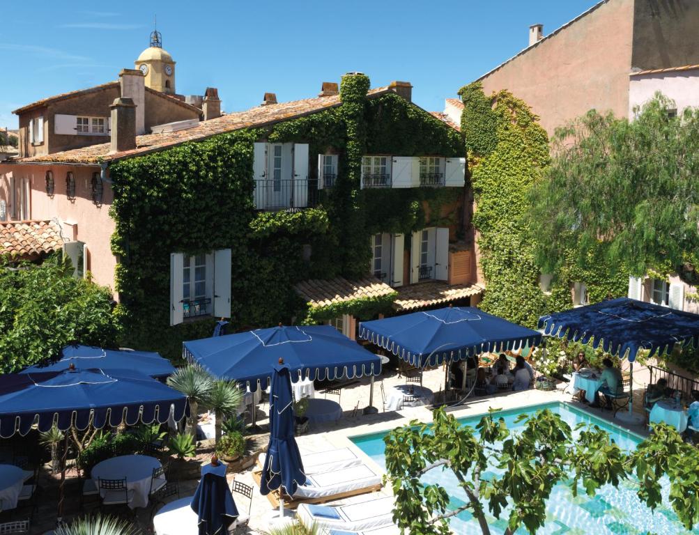 圣特罗佩Le Yaca Saint-Tropez的享有酒店游泳池和遮阳伞的景色
