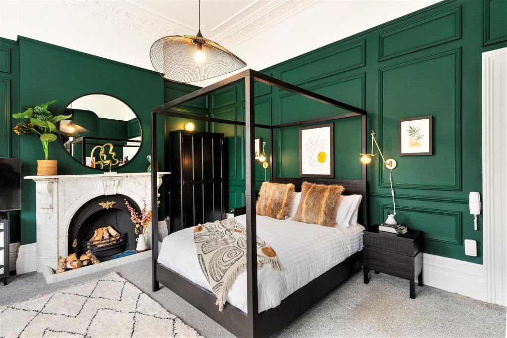 布里斯托Your Apartment I Clifton House的一间卧室设有绿色的墙壁和一张带壁炉的床。