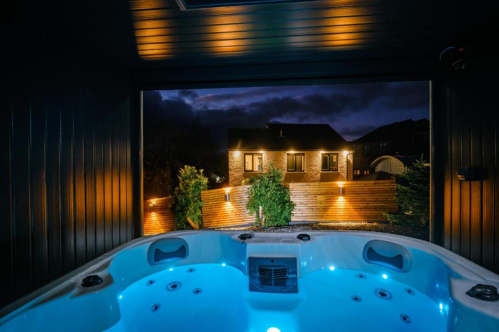 温德米尔Rockside - Luxury 1 bedroom home with hot tub central, parking pet friendly hot tub turns off 930pm的晚上在后院的按摩浴缸