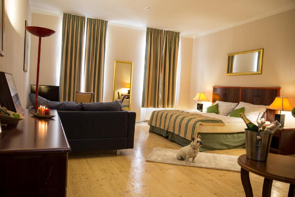 卡罗维发利紫水晶公寓酒店的卧室配有床,卧室内有一只狗