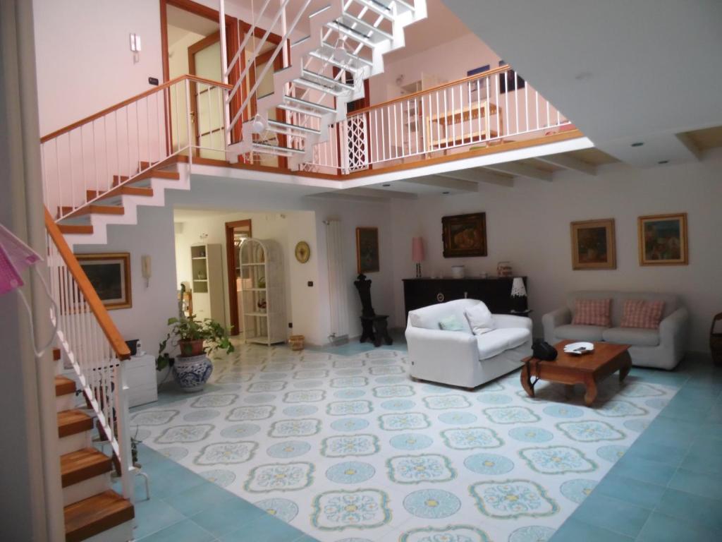 波佐利A Casa di Monica的一间带楼梯和沙发的客厅
