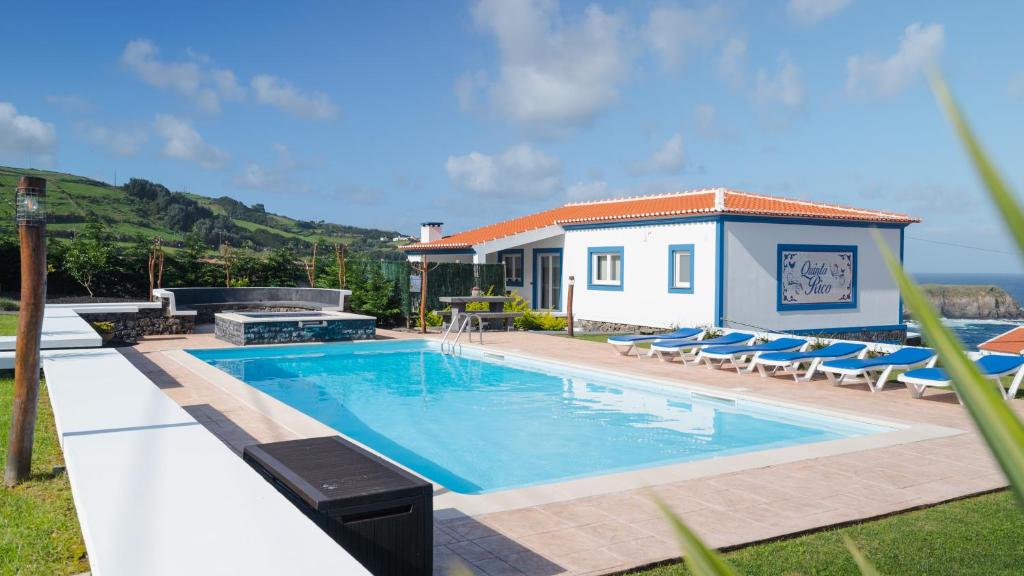 普拉亚达维多利亚Quinta Rico - House II的一个带椅子的游泳池以及一座房子