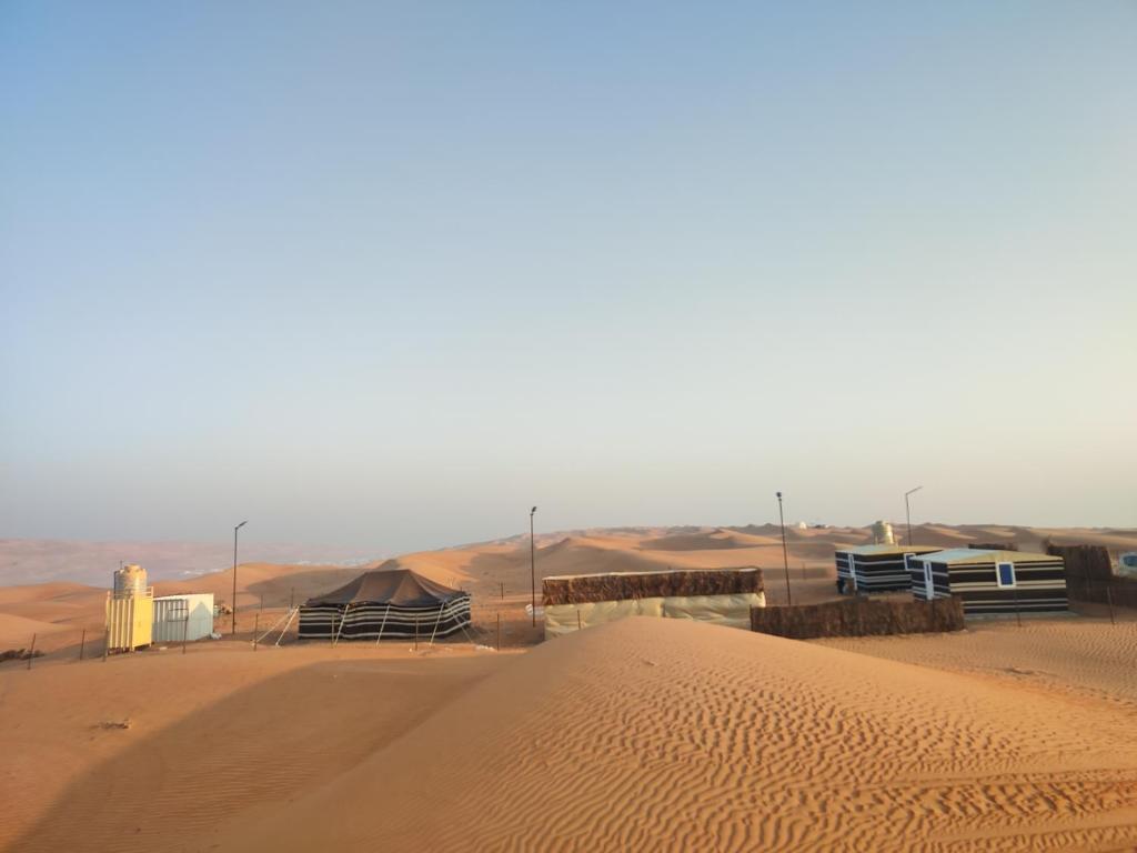 Al WāşilBidiya Dunes camp عزبة بدية ديونز的沙漠中间有一座建筑