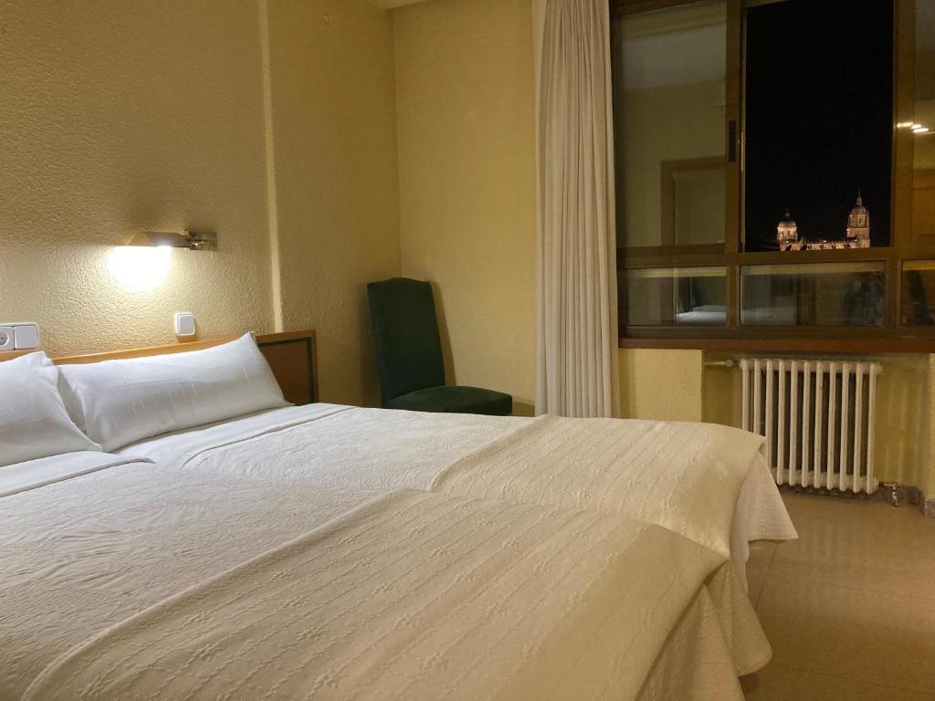 萨拉曼卡康达尔酒店的卧室设有一张白色大床和一扇窗户。