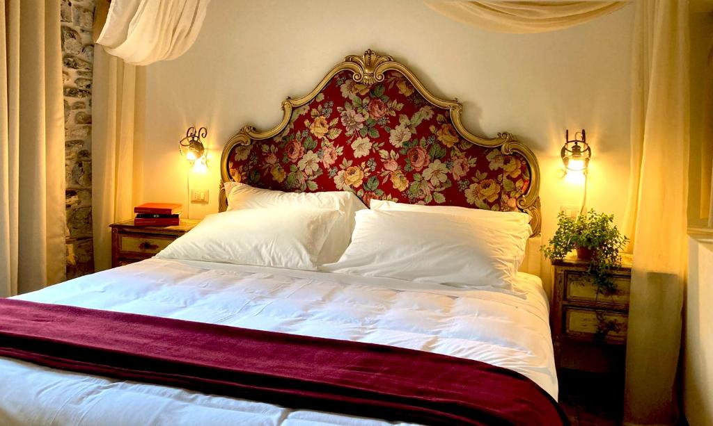 莱泽诺La Corte del Governo 565的一间卧室配有一张大床和花卉床头板