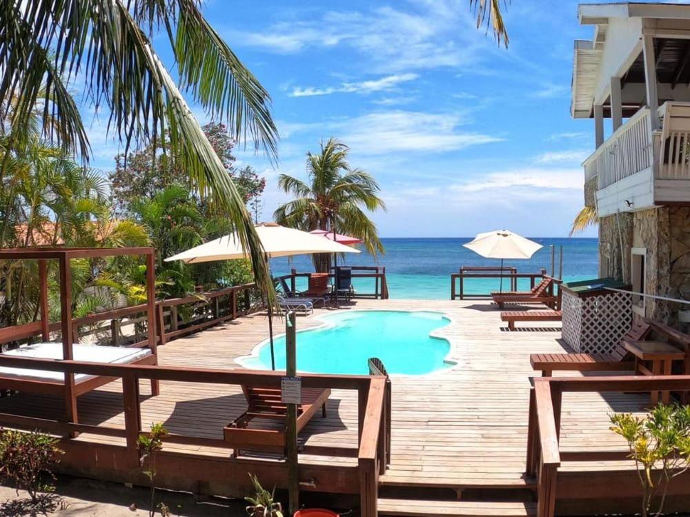 西湾Coconut Tree West Bay的一个带游泳池和海洋的度假甲板