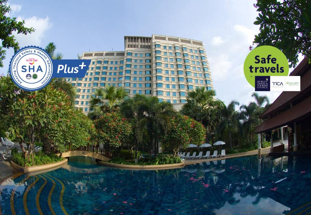 曼谷Rama Gardens Hotel Bangkok - SHA Plus Certified的大型建筑前的大型游泳池