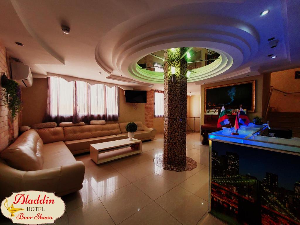 贝尔谢巴阿拉丁贝尔谢巴酒店的带沙发和棕榈树的客厅