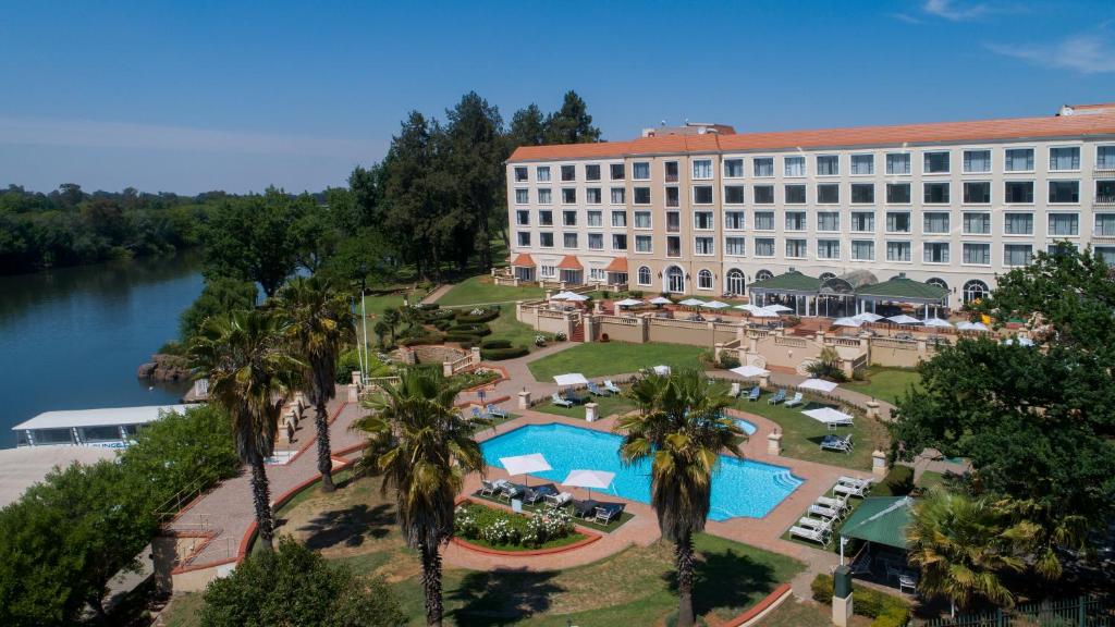 弗里尼欣Riviera on Vaal Resort的享有酒店空中景色,设有游泳池和棕榈树