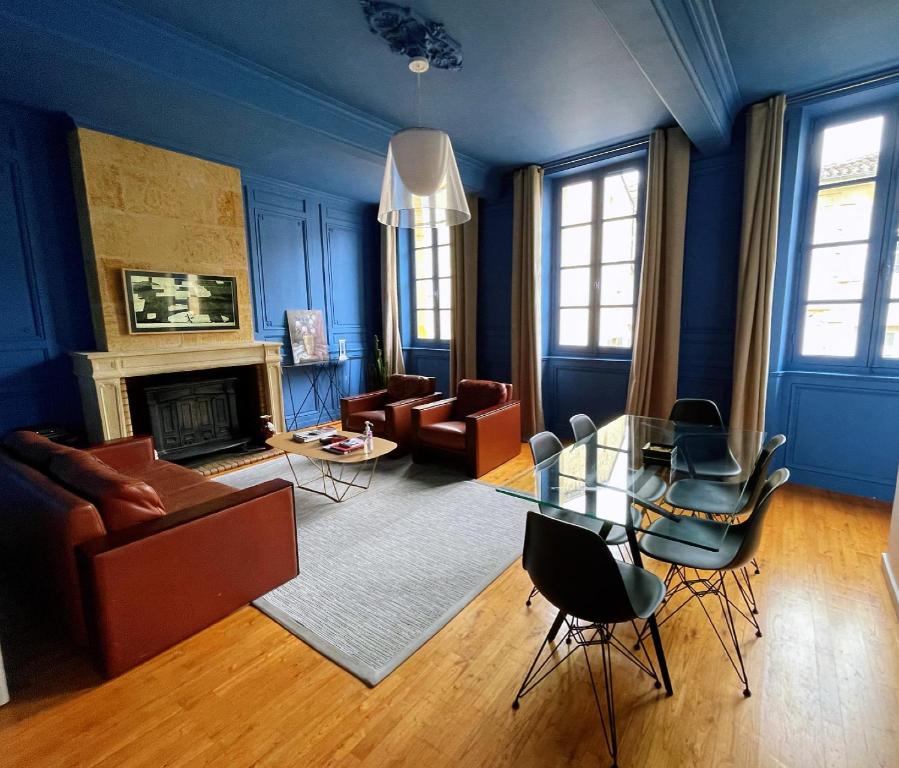 圣艾米隆La Petite Fontaine的蓝色的客厅配有玻璃桌和椅子