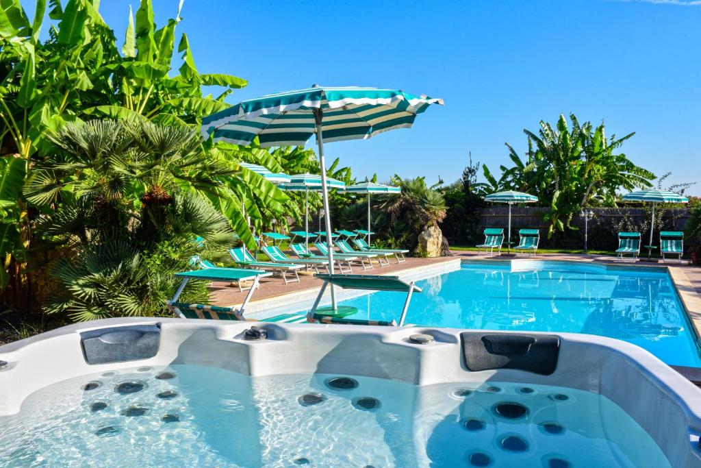 阿尔盖罗德斯德里喷泉酒店的度假村的游泳池,配有椅子和遮阳伞