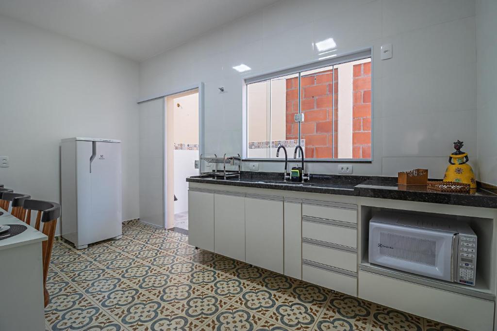 布罗塔斯Vila Pepira ViP的厨房配有水槽和冰箱