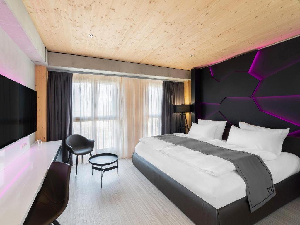 维也纳DORMERO HoHo Wien的一间卧室配有一张大床和紫色床头板