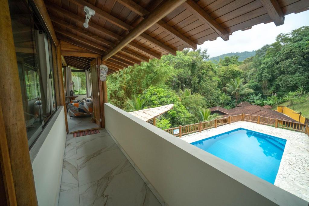 伊利亚贝拉Diver Village Ilhabela的从带游泳池的房屋阳台欣赏风景
