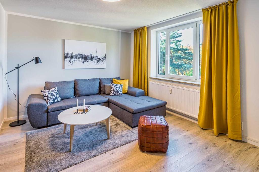 德累斯顿new apartment I cozy I Netflix I WLAN I near airport的客厅配有蓝色的沙发和桌子