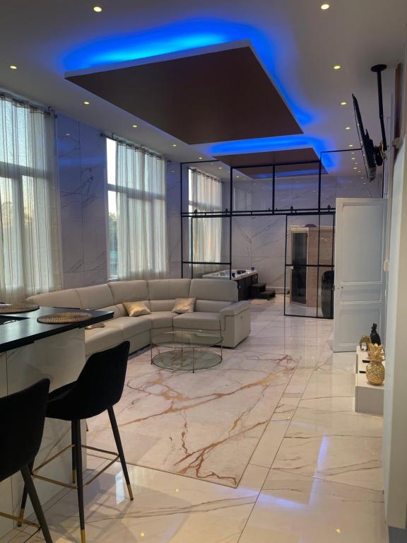 鲁昂Golden Suite - JACUZZI SAUNA的客厅配有沙发和桌子