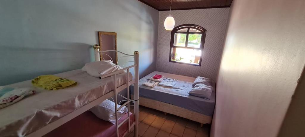 伊比乌纳Linda Chacara em IBIUNA的小房间设有两张床和窗户