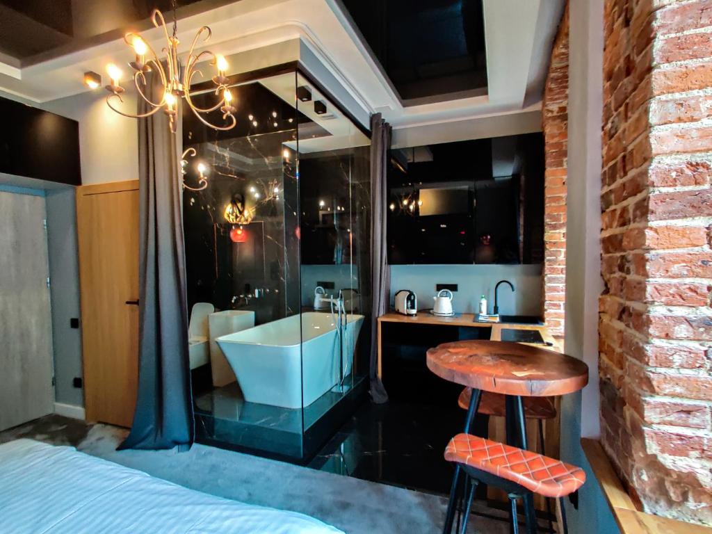 罗兹Piotrkowska.eu Apartament Romantica的带浴缸、水槽和凳子的浴室
