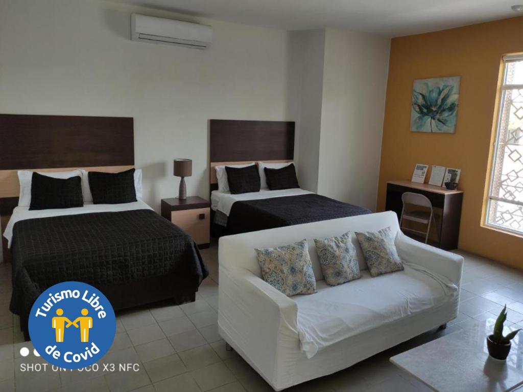 托雷翁Hotel del Bosque的酒店客房,设有两张床和一张沙发