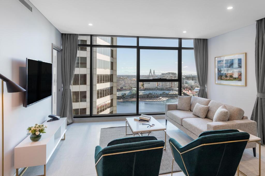 悉尼Meriton Suites Sussex Street, Sydney的带沙发和大窗户的客厅