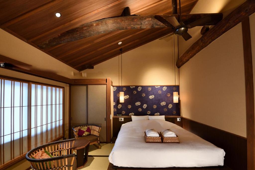 京都Muromachi Yutone Kyokoyado的一间带一张床的卧室,位于带木制天花板的房间内