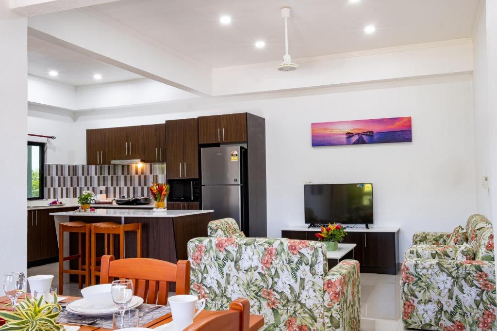 辛加东卡Coastal Suites Fiji的厨房以及带桌椅的起居室。