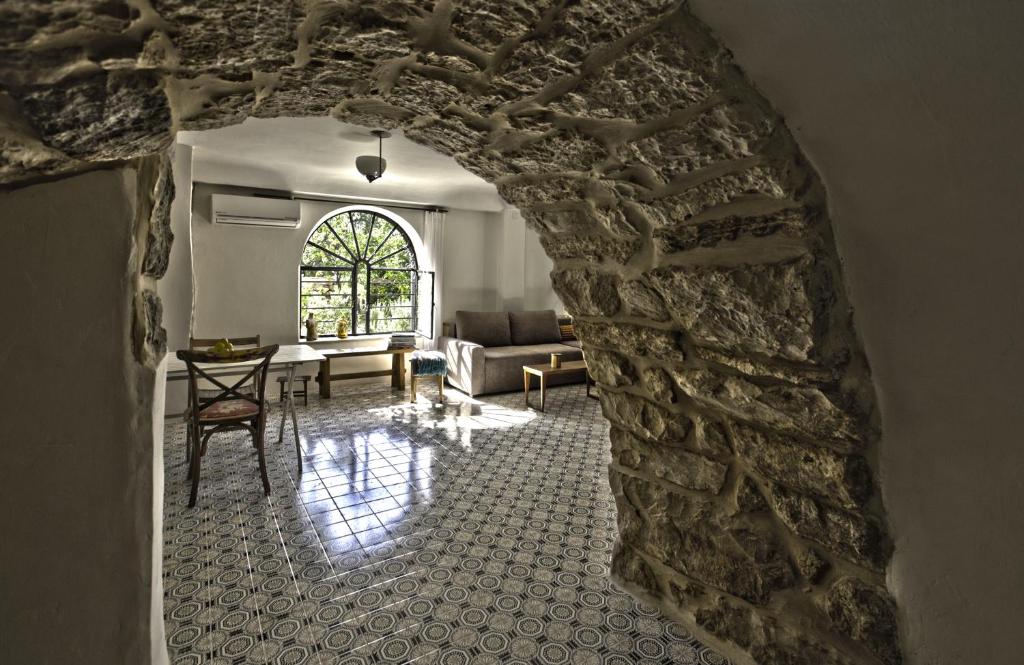 耶路撒冷耶路撒冷 - 巢 - 艾因凯雷姆浪漫度假屋的客厅设有石墙和沙发。