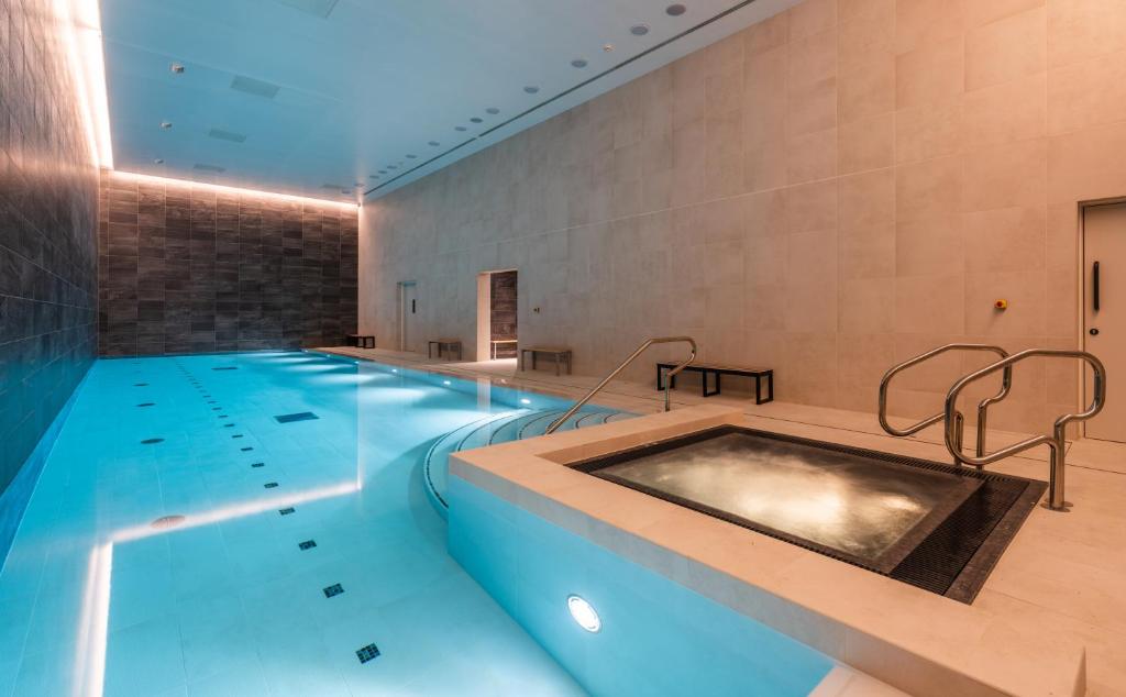 曼彻斯特CitySuites 2 Aparthotel的一个带热水浴缸的大型游泳池
