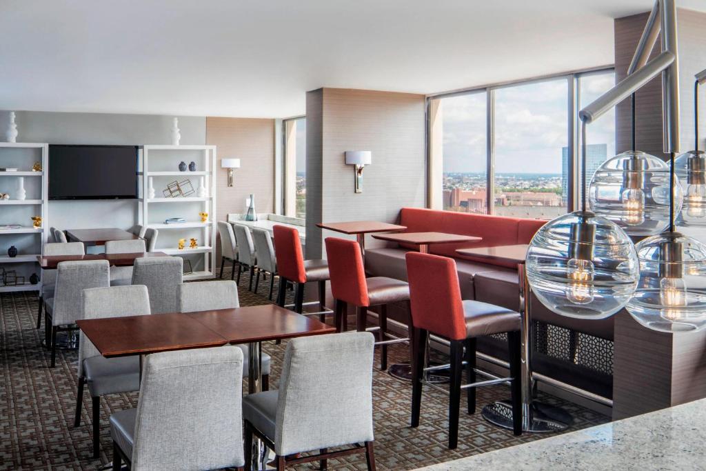 费城费城大学城喜来登酒店的餐厅设有桌椅和窗户。