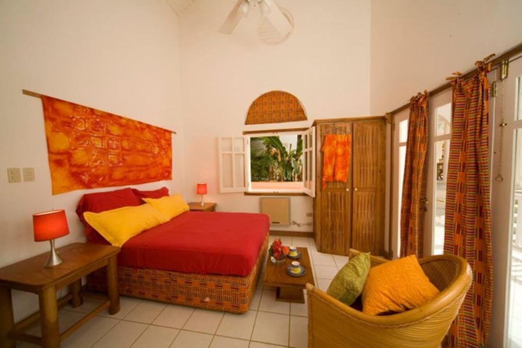 Mount Irvine多巴哥芙蓉高尔夫别墅及公寓的卧室配有一张床和一张桌子及椅子